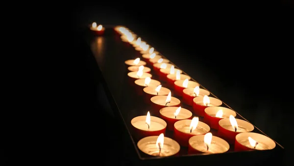 在教堂内举行的信众弥撒期间 点燃了点燃的祈祷的蜡烛 — 图库照片