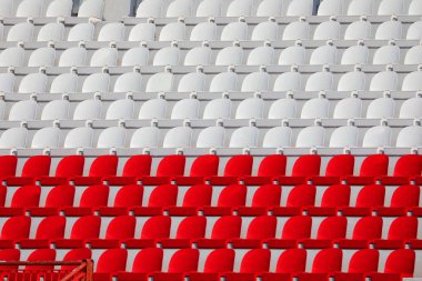 Stadyumda insanlar olmadan kırmızı ve beyaz koltuklar