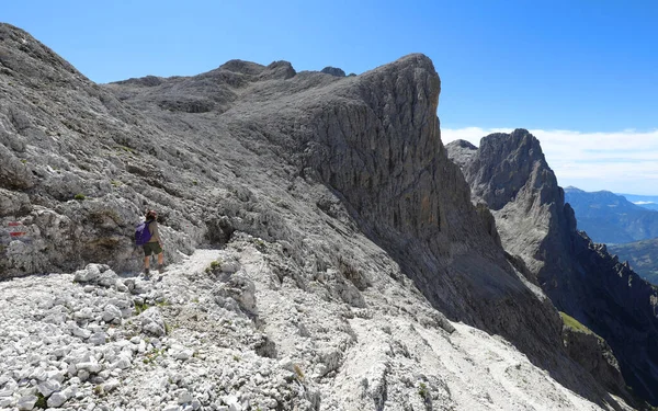 年轻女子背着背包走在意大利北部白云石阿尔卑斯山的路上 — 图库照片