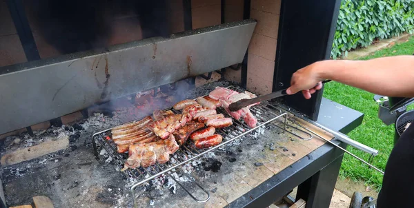Mano Del Cocinero Mientras Cocina Con Salchichas Barbacoa Costillas Cerdo —  Fotos de Stock