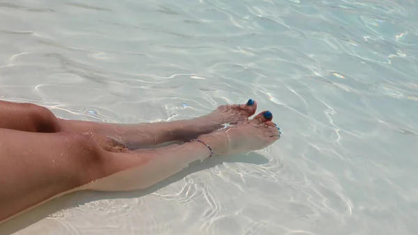 Długie Nogi Młodej Dziewczyny Nogami Kolorowym Lakierem Paznokci Tropikalnej Wodzie — Zdjęcie stockowe