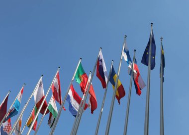 Parlamento ve mavi gökyüzü yakınlarındaki Avrupa ülkelerinin uluslararası bayrakları