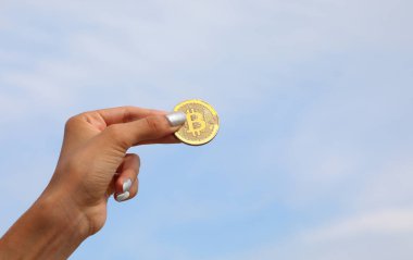 Kriptovalute bitcoin 'in B sembolü olan sikkeyi tutan bir kadın.