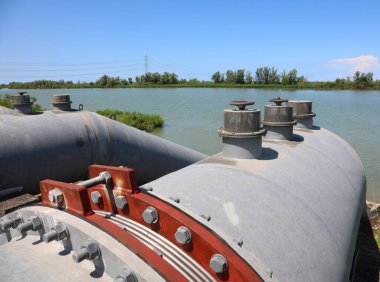 Bölgeyi su basmasını önlemek için güçlü arıtma pompalarının büyük çelik boruları.