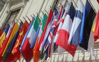 Hükümet binasının dışında asılan pek çok dünya ülkesinin renkli bayrakları.