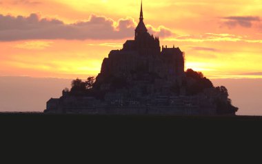 Kuzey Fransa 'da Normandiya' daki Mont Saint Michel Manastırı 'nda gün batımında turuncu gökyüzü