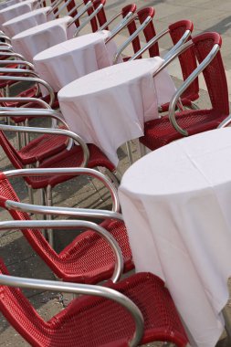 Avrupa 'da müşterileri bekleyen beyaz masa örtüsü ve boş sandalyeli açık masa