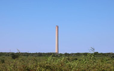 Porto Tolle, RO, İtalya - 5 Temmuz 2023: Po Valley 'deki bir termoelektrik santralinin büyük bacası