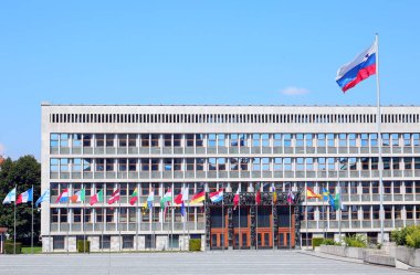 Ljubljana, L, Slovenya - 16 Ağustos 2023: Slovenya Parlamentosu Avrupa başkenti binası ve büyük dalgalı bayrak