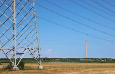 Elektrik nakli için yüksek voltaj kabloları ve termoelektrik santralinin bacası olan pilon.