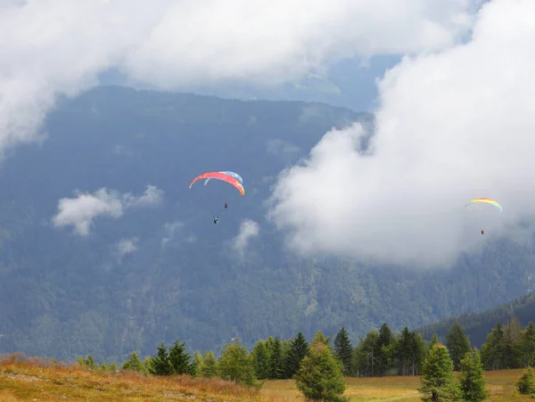 stock image some paragliders even have two people flying at the same time in the clouds in the mountains