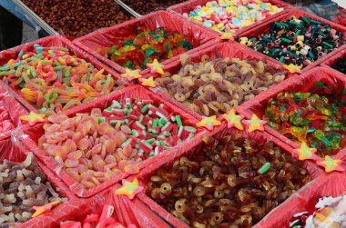 Şekerleme tezgahının tezgahında çocuklar için çok şekerli şekerler ve tatlıya düşkün yetişkinler için