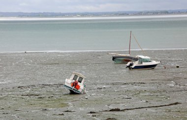 Kuzey Fransa 'da, Brittany' de dalgalar çekildiğinde kıyıya vurmuş motorlu tekneler.