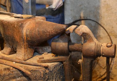 Kitaplığın içinde çok ağır demir örsler ve hareket eden demircinin çekiç sesi.