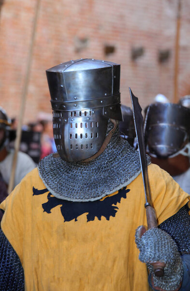 medieval knight with armor and protective metal helmet on his head during a historical reenactment