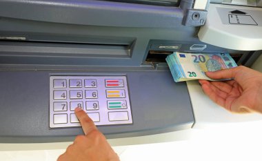 Gizli kodu yazarak bankadaki 20 avroluk banknotları çeken bir gencin eli