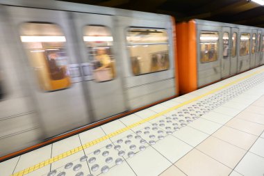 Metro vagonu, metro istasyonunda neredeyse bulanık bir hareket etkisiyle hızla ilerliyor.