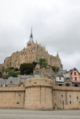 Mont Saint Michel Manastırı ve koruyucu duvarlar alçak gelgit sırasında sahil yanında kimse olmadan.