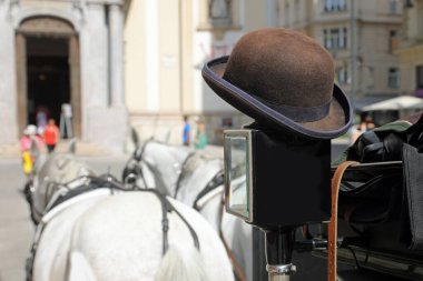 Avrupa şehrinde turistleri arabasına alan arabacının melon şapkası.