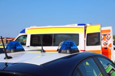 Polis arabasının sirenleri ve trafik kazasından sonra ambulansın arka planında yaralanmalar var.