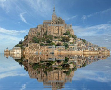 Kuzey Fransa 'da Normandiya' da Mont Saint Michel Manastırı ve mavi gökyüzü ile tepenin yükselen sularına bakın.