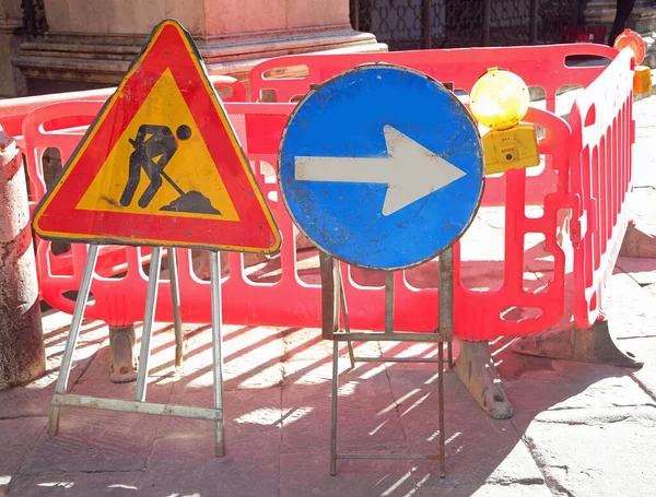 road construction site in the city and the signs with the big arrow and the yellow flashing light