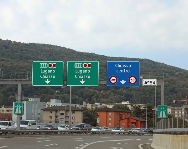 Οδικές Πινακίδες Για Τις Πόλεις Chiasso Και Lugano Κοντά Στα Εικόνα Αρχείου