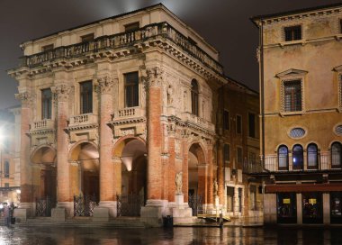 Vicenza, VI, İtalya - 15 Ocak 2023: Loggia del Capitaniato Sarayı 'nın ana meydandaki görüntüsü yağmurda gece yansımaları ile birlikte