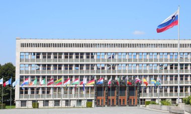 Ljubljana, L, Slovenya - 15 Ağustos 2023: Slovenya Parlamentosu Avrupa başkenti binası ve el sallayan bayrak