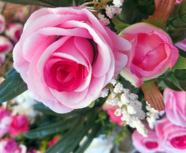 Kumaş ve plastik pembe gül çiçekleri üretimi ve pazarda satılık diğer çiçeklerin buketleri.