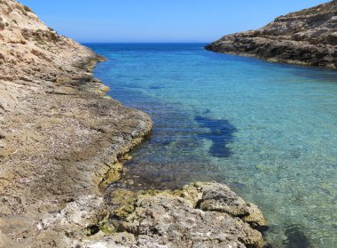 Akdeniz adasının mavi denizi ve kayalık kıyıları olan insansız bir panorama