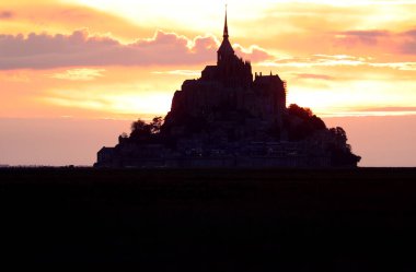 Kuzey Fransa 'nın Normandiya bölgesinde gün batımında antik Mont Saint Michel Manastırı' nın siyah silueti