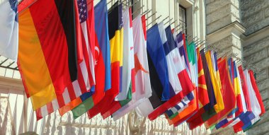 Uluslararası kongrede insanlar olmadan sallanan dünya devletlerinin renkli bayrakları