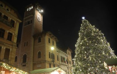 Asiago, VI, İtalya - 9 Aralık 2023: Büyük Noel Ağacı ve dağlardaki küçük kasabada ışıklar ve kamu binası