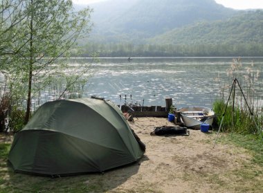 Balıkçılık yaparken gölün kenarında bir balıkçı çadırı