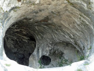 Tarih öncesi çağda ilkel insanlar tarafından barınak ve barınak olarak kullanılan kayalık dağın içinde büyük mağaralar kazıldı.