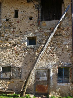 Çok uzun tahta merdiven kırsal bir çevrede antik ahırın duvarına eğik duruyor.