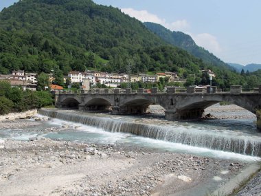 Kuzey İtalya 'nın Karnia bölgesinde CEDARCHIS Villaage yakınlarında bir nehir ve köprü.