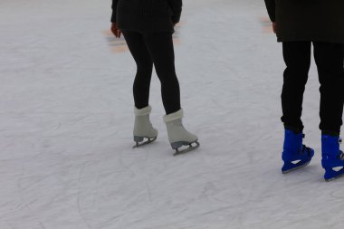 Kışın buz pateni pistinde kayan sporcunun zarif buz patenlerini.