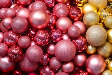 Noel tatilini kutlamak için altın ve fuşya renklerinde renkli Noel mücevherlerinin arka planı