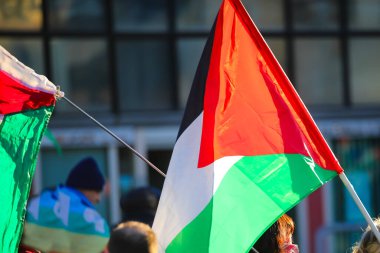 Büyük Filistin bayrağı barışçıl gösteri sırasında birçok insanla birlikte savaşı durdurmak ve barış istemek için el salladı.