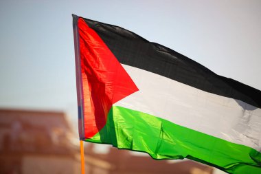 Büyük Filistin bayrağı şehirde insanlar olmadan ışığa doğru dalgalanıyor.