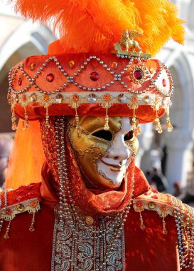 Kutlama sırasında maskeli ve maskeli tanınmayan bir yüz ve büyük bir şapka takıyor.