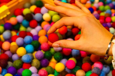 Hobi dükkanında kırmızı yün toplu bir kız.