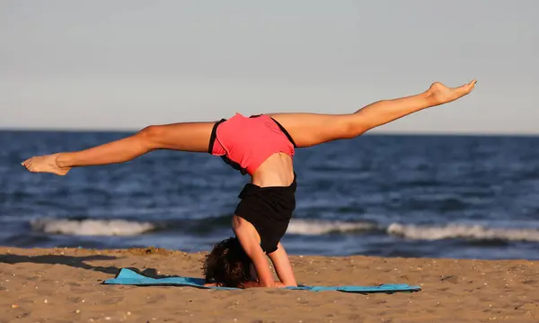 Λεπτή Κοπέλα Εκτελεί Ασκήσεις Γυμναστικής Σωματικού Βάρους Στην Παραλία Εικόνα Αρχείου