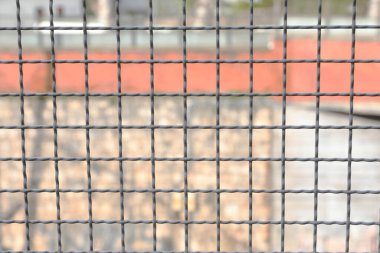 Metal sınır ayırma ağı ve bina duvarı arka planda kasıtlı olarak bulanık