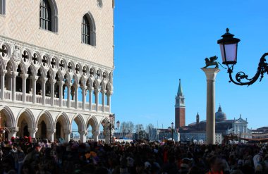 Venice, VE, Italy - February 13, 2024: People and Corner of Ducal Palace called PALAZZO DUCALE in Italian language and the bell tower of Saint George Basilica clipart