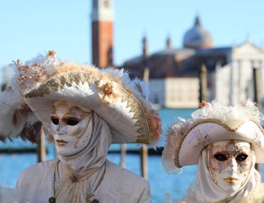 İtalya 'daki Venedik Karnavalı' nda tanınmayan yüzleri olan beyaz maskeli bir çift. Tarihi Aziz George Bazilikası.