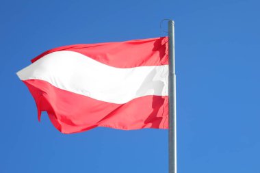 Austrian flag on blue sky background in Vienna  Austria clipart