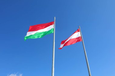 Avusturya ve Macaristan bayrakları mavi gökyüzünde eski Avusturya-Macaristan İmparatorluğu anısına birlikte dalgalanıyor